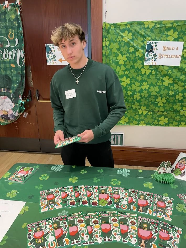 Sammy volunteering at a St. Patrick’s Day craft table